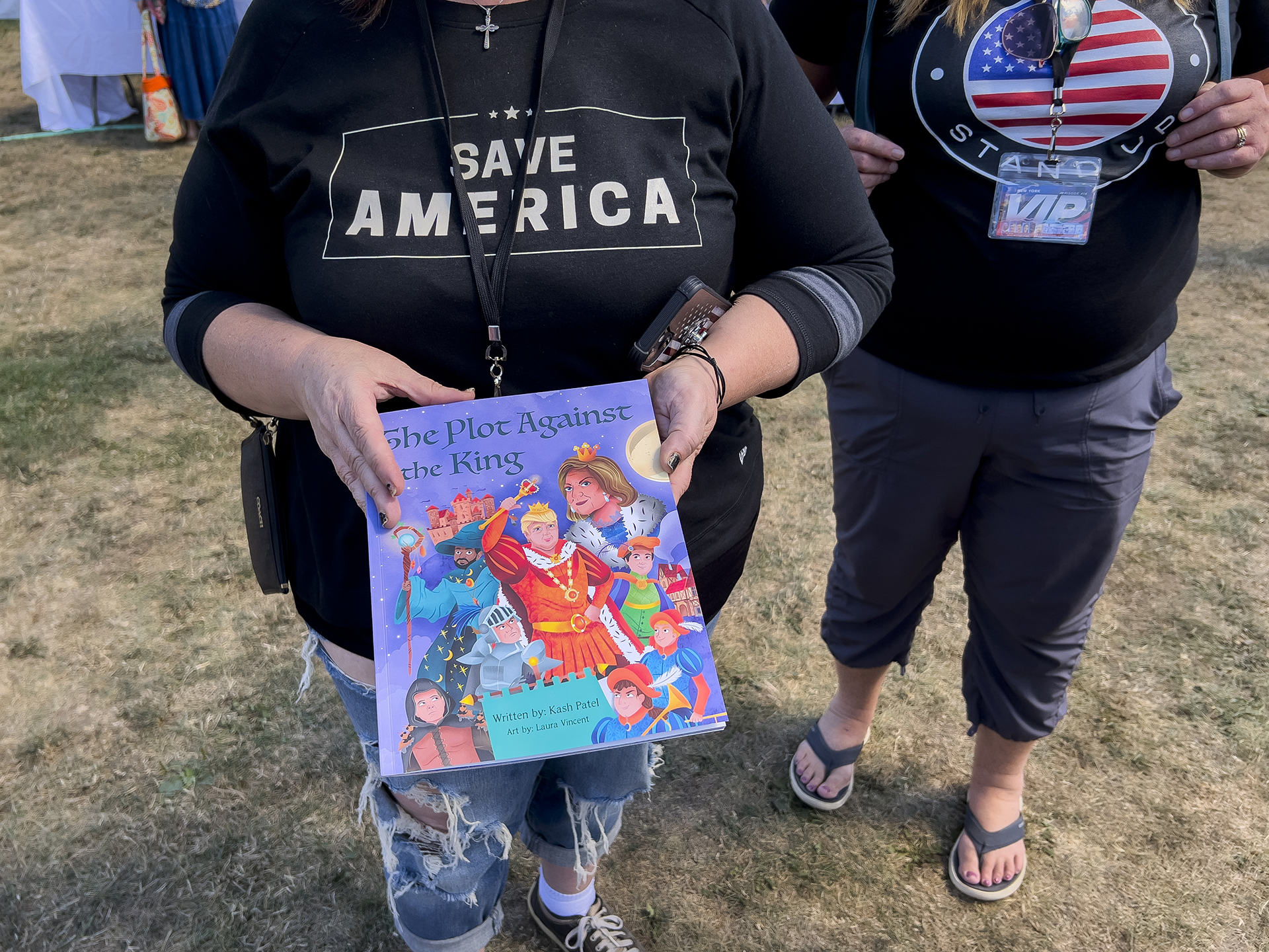 A woman holds her autographed copy of the children’s book “The Plot Against the King” by former Trump administration official Kash Patel during the ReAwaken America tour at Cornerstone Church in Batavia, N.Y., Friday, Aug. 12, 2022. (AP Photo/Carolyn Kaster)