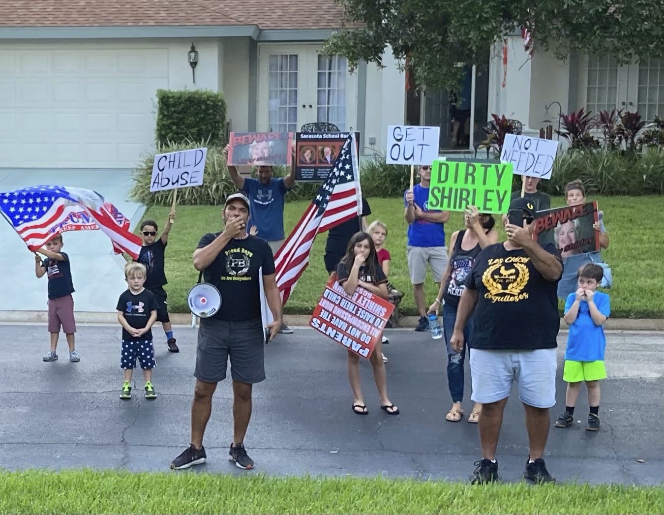 In this photo provided by former Sarasota County School Board Chair Shirley Brown, Proud Boy member James Hoel and others gather outside her home for an anti-mask protest on Oct. 4, 2021. "We see you in there, Shirley. We want you to come out for a redress of grievances," Hoel said through a megaphone.