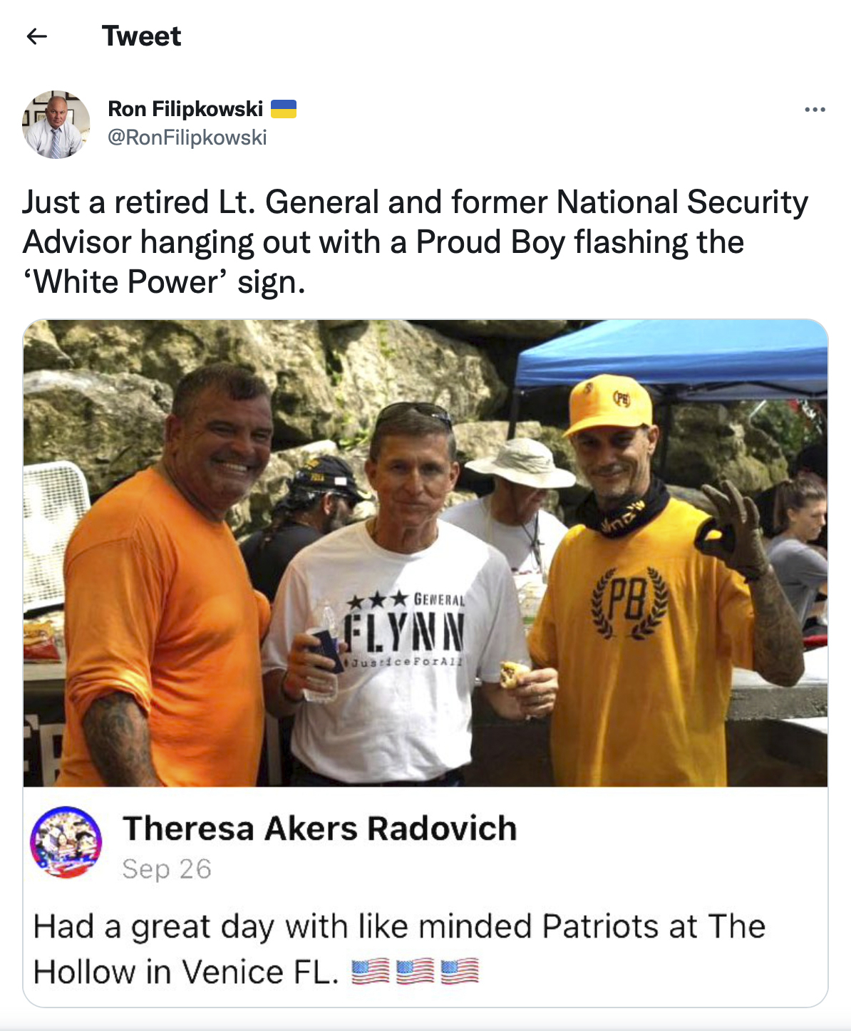 This image from the Twitter account of Sarasota, Fla., lawyer Ron Filipkowski, who tracks far-right figures online, shows a photo originally posted on Facebook on Sept. 26, 2021, of Michael Flynn, center, eating a hot dog with Victor Mellor, Sr., owner of The Hollow, left, and an unidentified man in a Proud Boys shirt, at Mellor's venue in Venice, Fla.