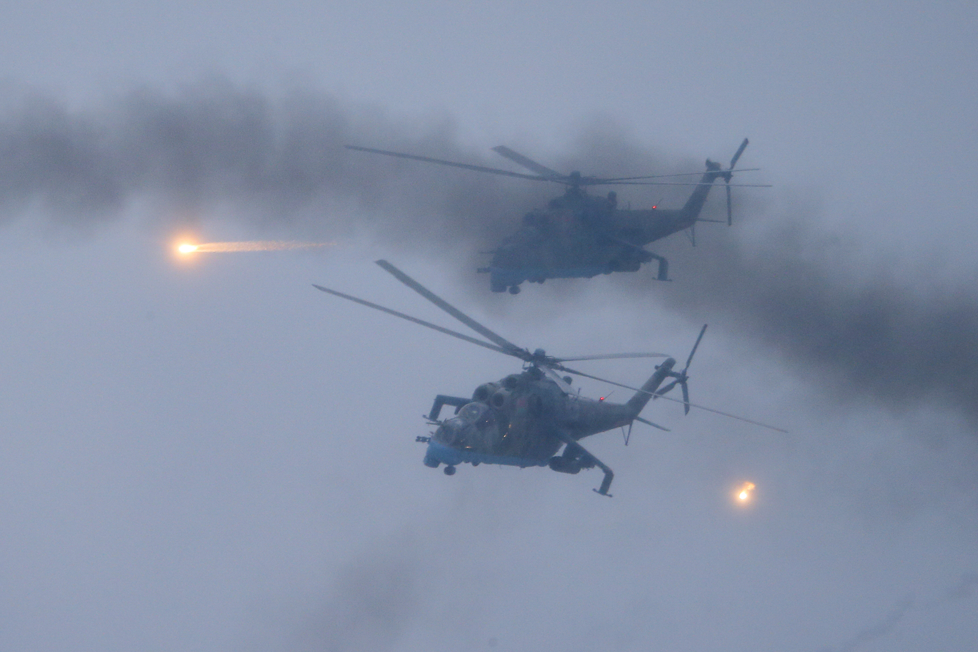 Military helicopters fly over the Osipovichi training ground during the Union Courage-2022 Russia-Belarus military drills near Osipovichi , Belarus, Thursday, Feb. 17, 2022. (AP Photo/Alexander Zemlianichenko Jr., File)