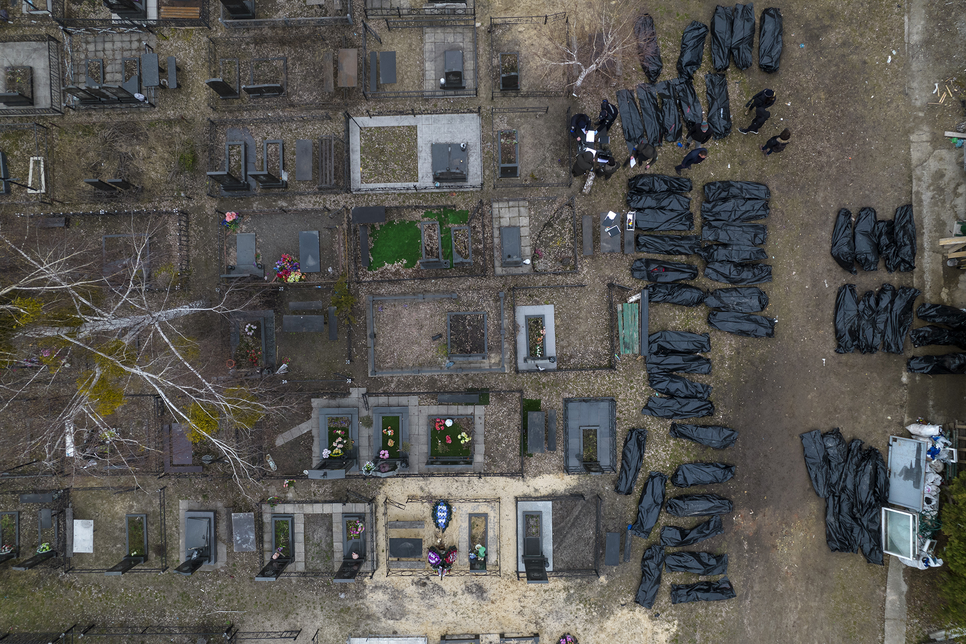 Policemen work to identify civilians who were killed during the Russian occupation in Bucha, Ukraine, on the outskirts of Kyiv, before sending the bodies to the morgue, Wednesday, April 6, 2022. Russian soldiers in intercepted phone conversations called their sweeps of Bucha and other towns “zachistka” — cleansing. They hunted people on lists prepared by their intelligence services and went door to door to identify and neutralize potential threats. (AP Photo/Rodrigo Abd, File)