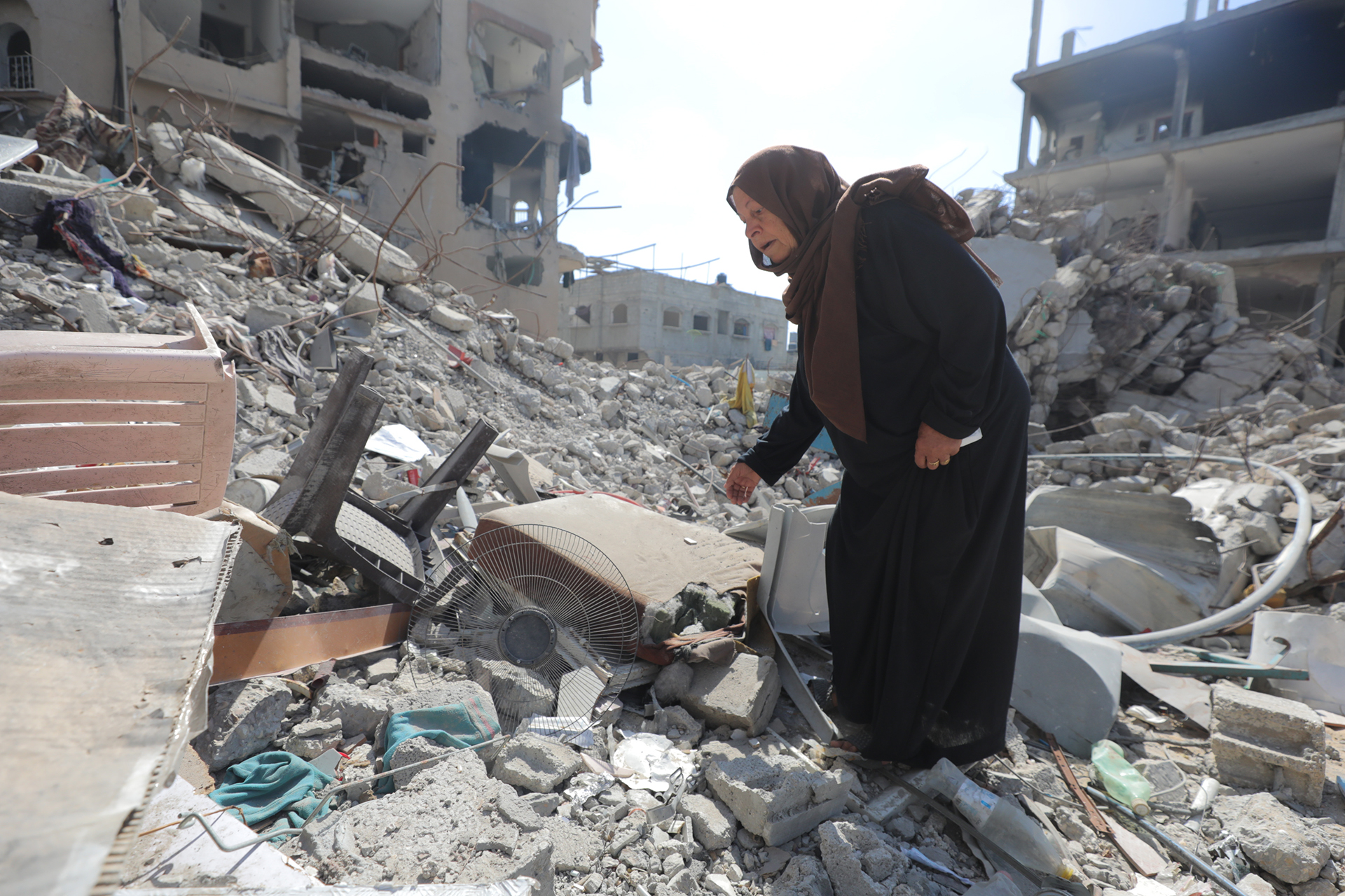 GAZA STRIP - JUNE 18: Palestinian mother Watfa Mahmud Al-Nashash walks among the debris at the Bureij refugee camp, after she lost four of her children as a result of an Israeli attack at the Gaza Strip on June 18, 2024. She has been able to recover and bury only one of their bodies. Al-Nashash continues to live amidst the ruins of her demolished home, as she continues to search for the bodies of her other children among the debris. (Photo by Hasan Jedi/Anadolu via Getty Images)