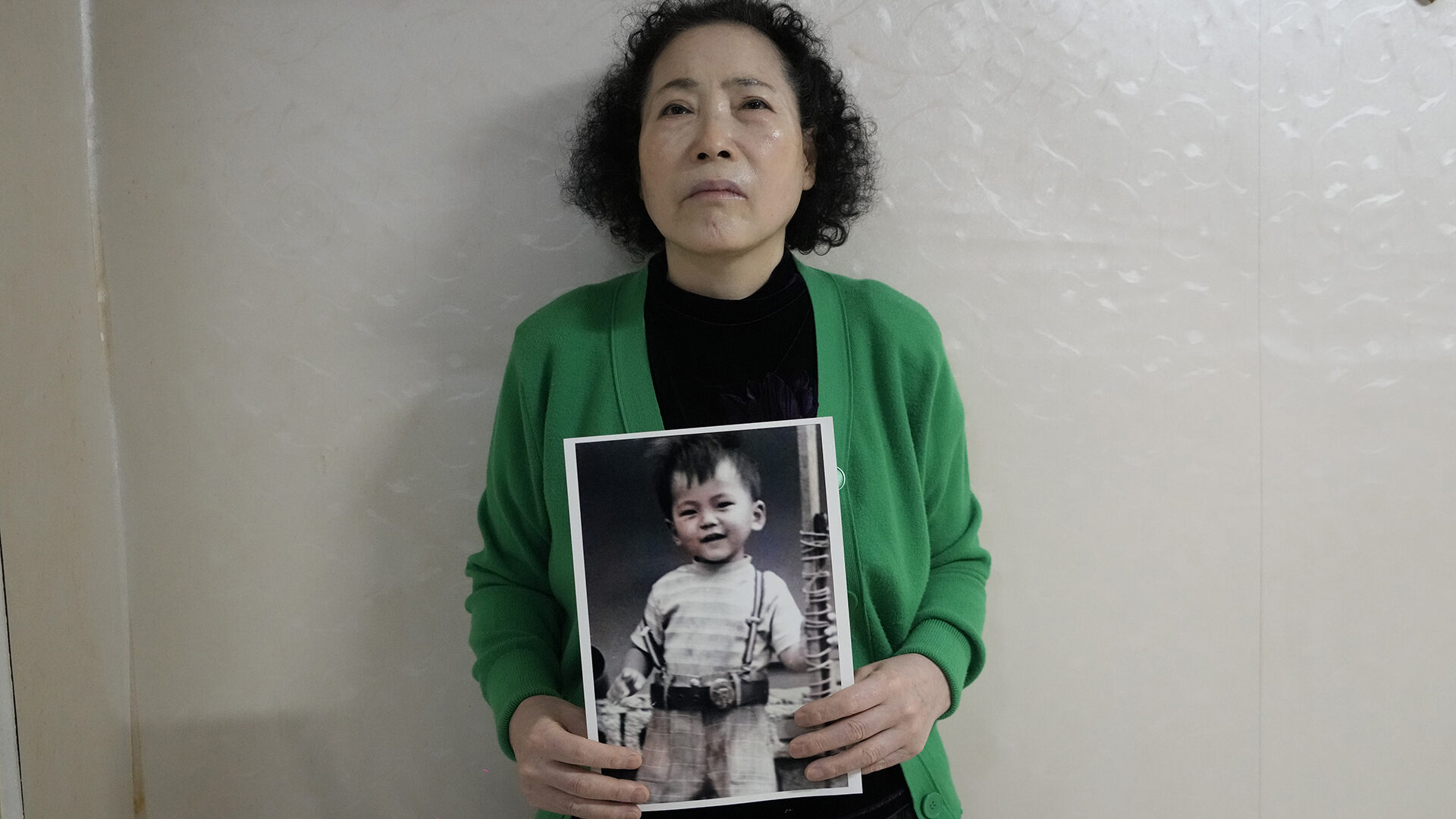 Choi Young-ja holds a photo of her son who went missing in 1975 in her motel room in Seoul, South Korea, Tuesday, March 5, 2024. She searched for him for decades, before recently learned he was adopted to a family in Norway. (AP Photo/Ahn Young-joon)