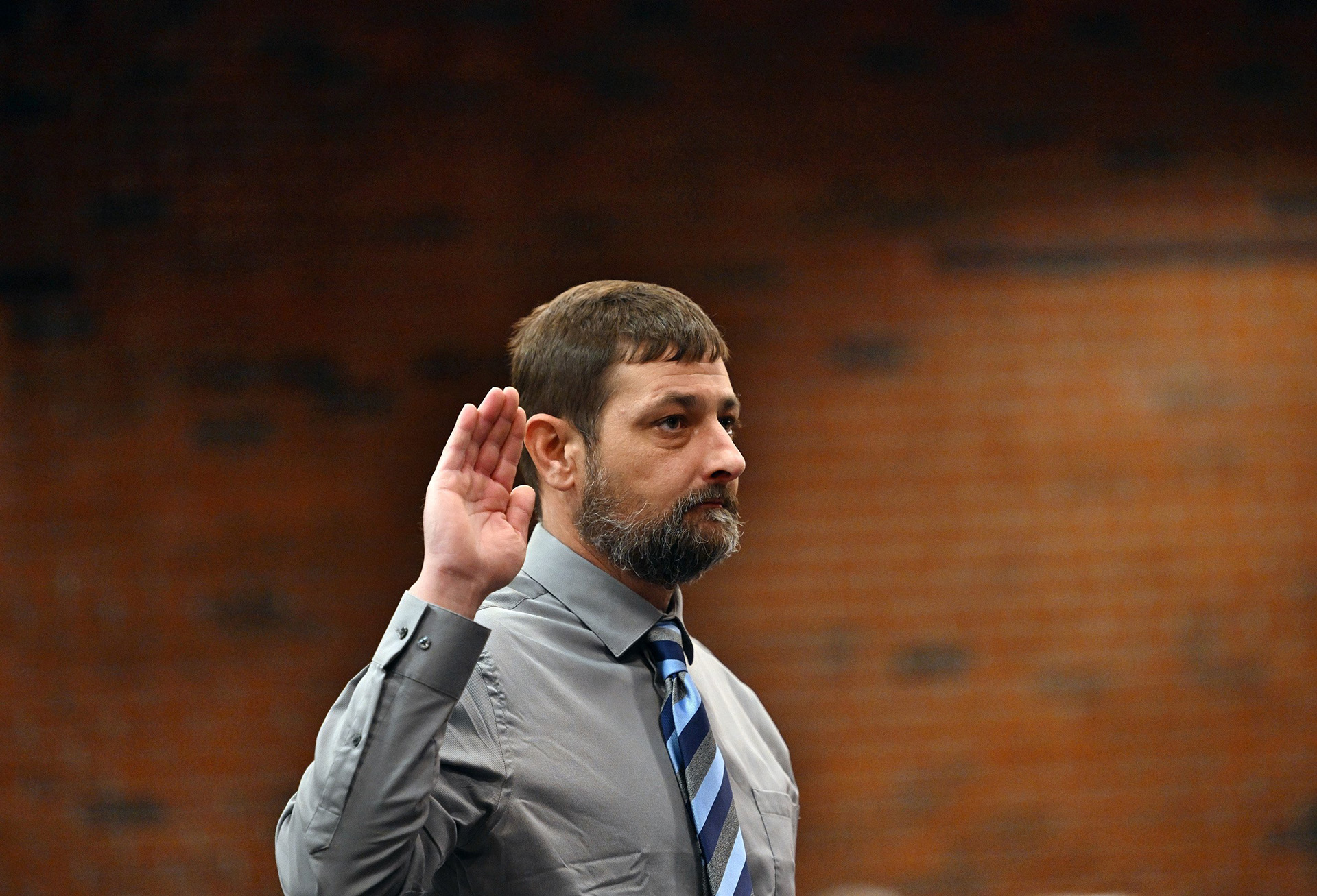 Sean Hodgson raises his right hand as he is sworn in to give testimony in front of the commission investigating the Lewiston mass shooting on April 25.