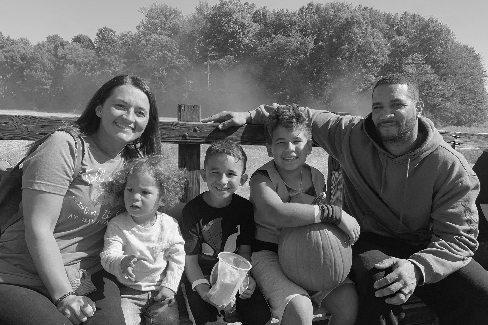 In this photo provided by the family, Asson Hacker, right, sits with his wife and their children during a trip to the Mayse Farm pumpkin patch in Evansville, Ind., in October 2022. (Family photo via AP)