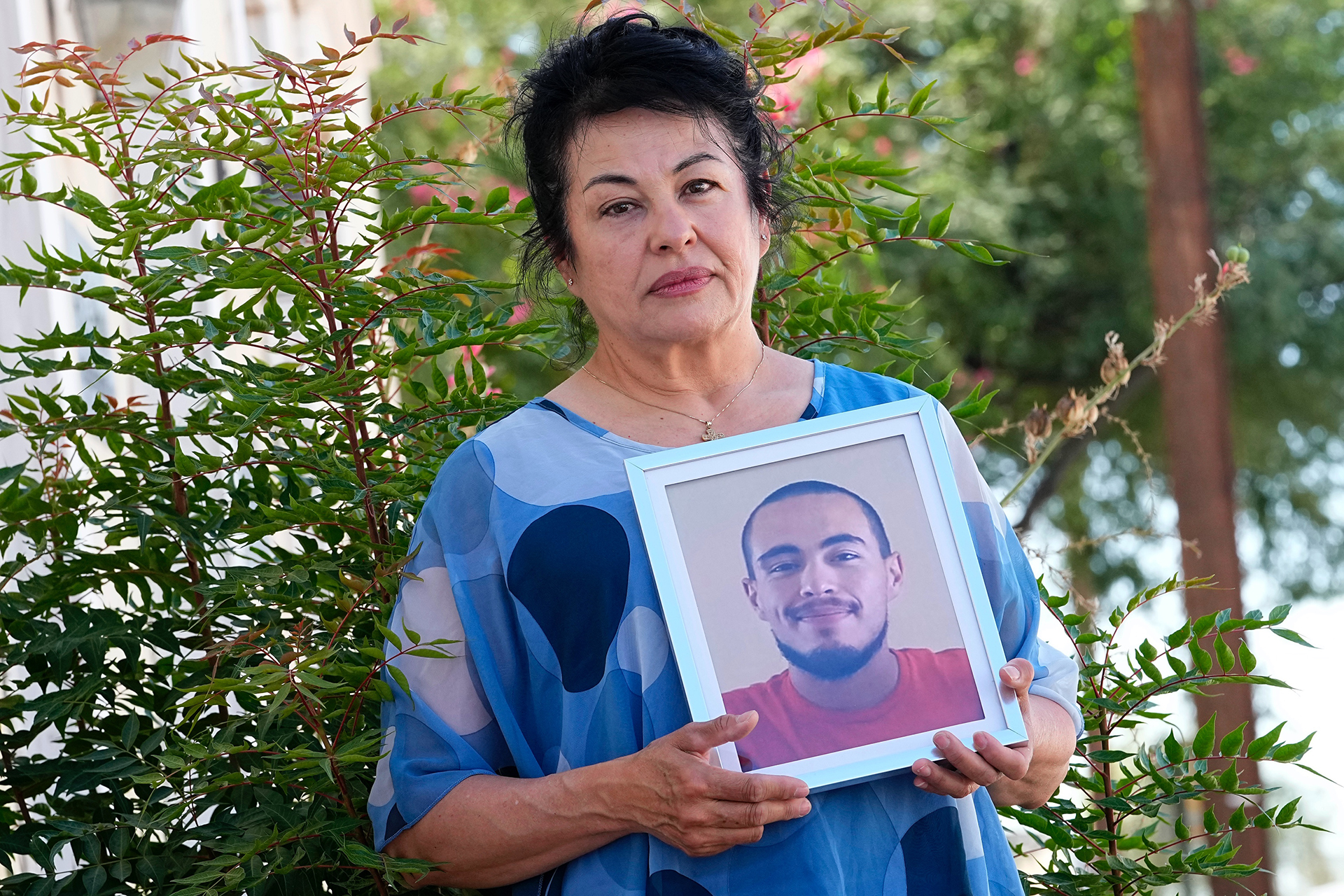Irene Alvarado holds a photo of her son, Damien Alvarado, outside her attorneys' office in Tucson, Ariz., on Oct. 4, 2023. (AP Photo/Matt York)