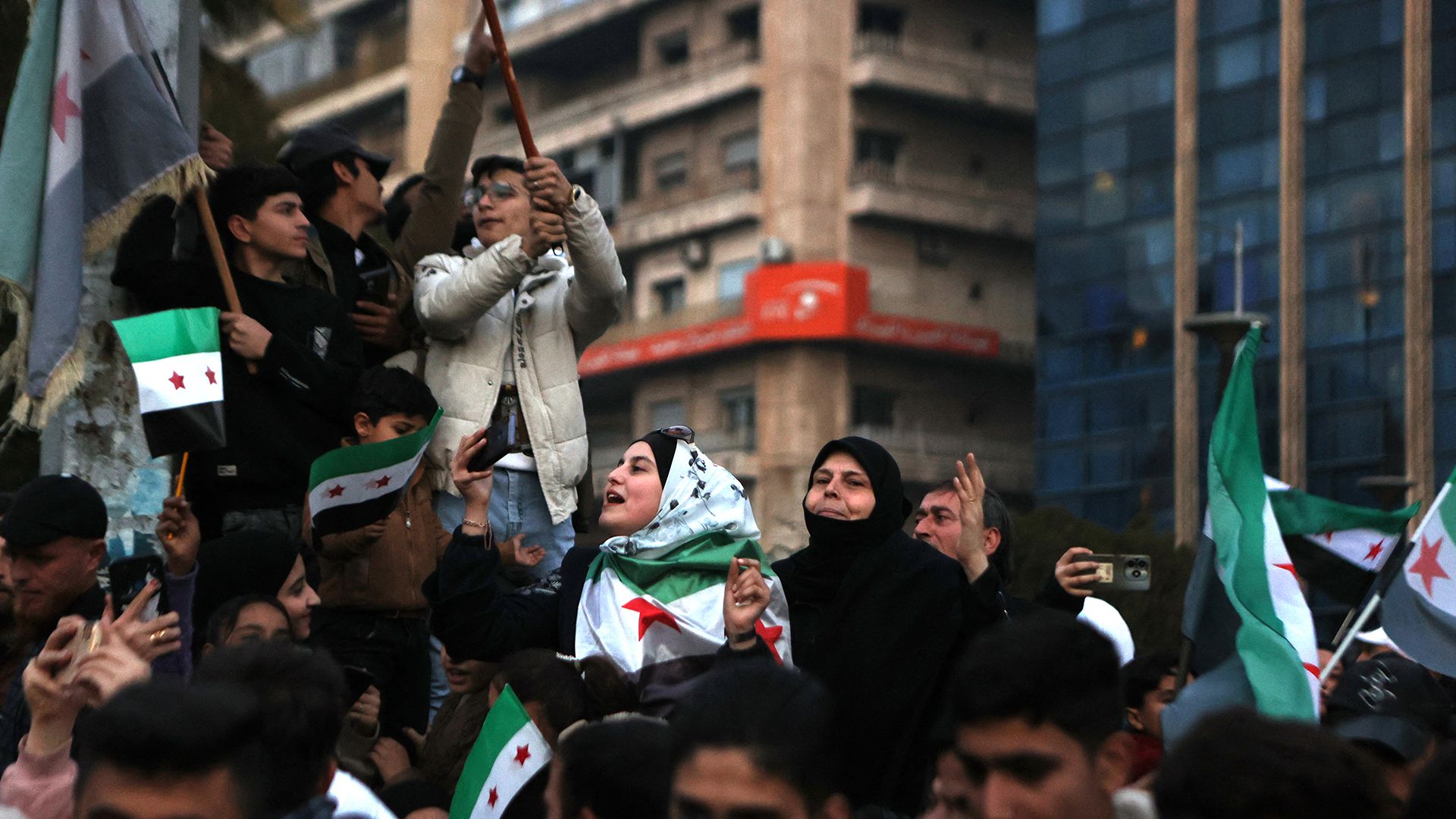 People wave independence-era flags in Aleppo, celebrating the fall of President Bashar al-Assad on December 21, 2024.
