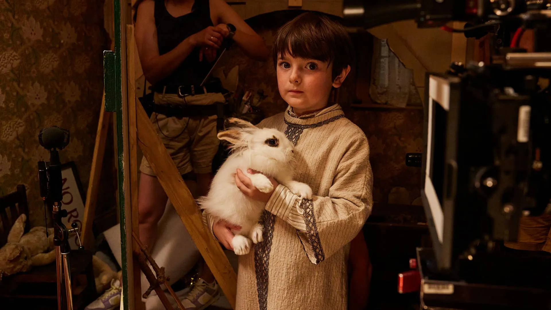 Thomas Riches (Jimmy), in his nativity play costume and with a very sincere expression on his face, gently holds a big white bunny.