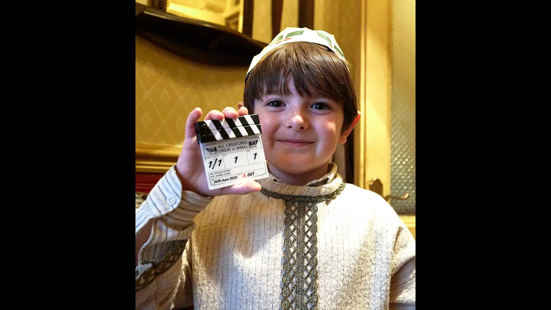 Smiling proudly, Thomas Riches (Jimmy) holds up to the camera a mini film clapper that he was given as a wrap present.