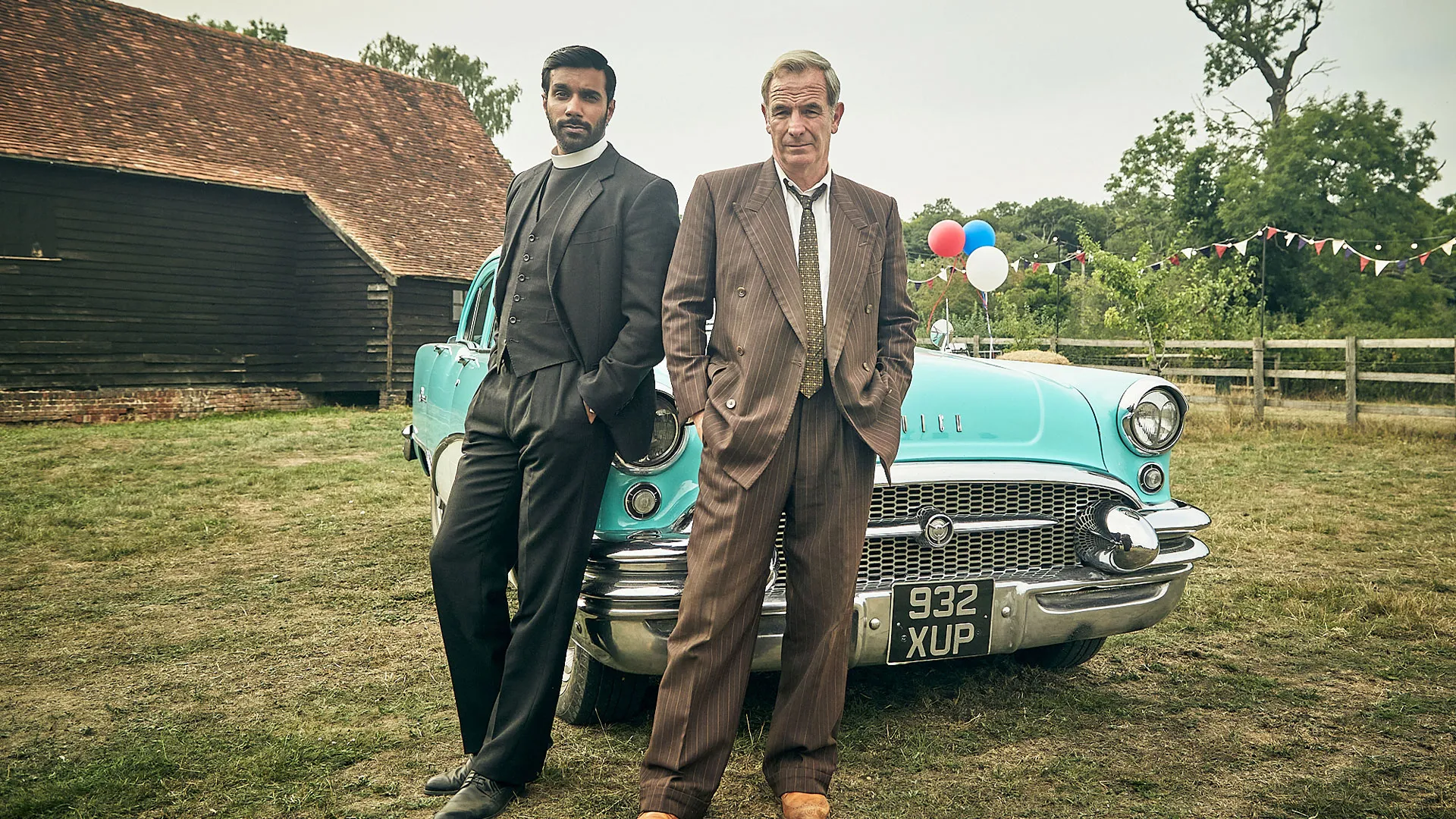 Rishi Nair as Alphy and Robson Green as Geordie standing by a car in Grantchester Season 11