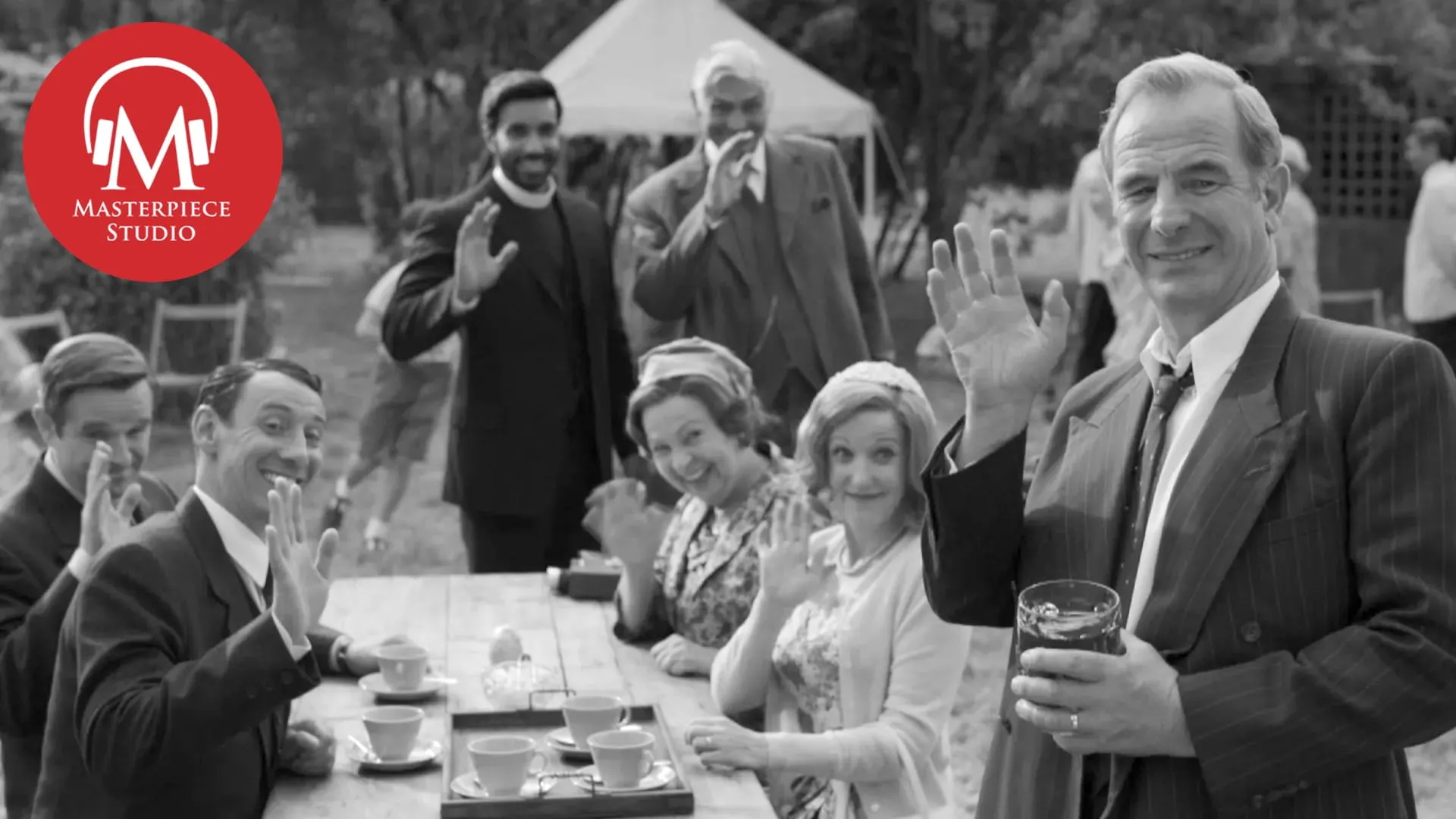 Black and white photo of grantchester characters waving to the viewer with the red MASTERPIECE Studio logo in the top left