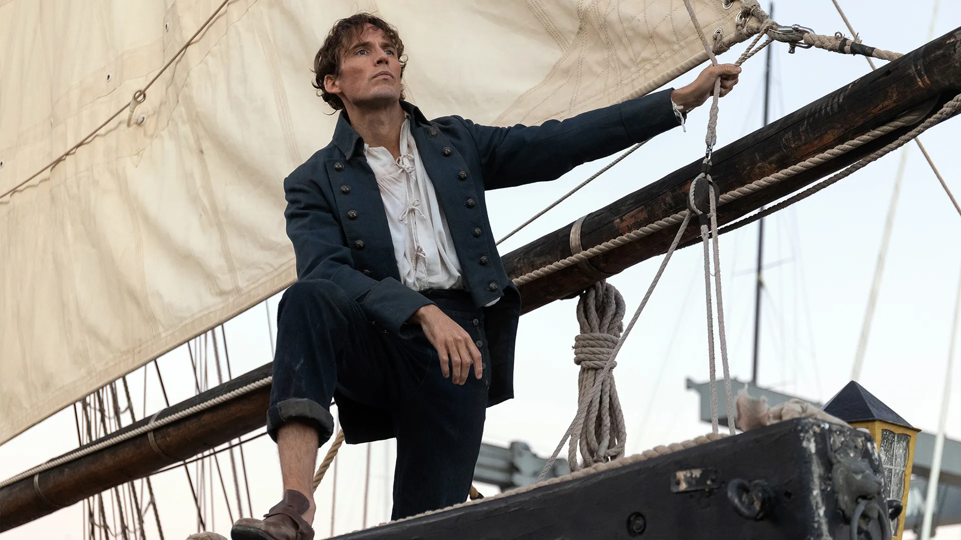 Sam Claflin as Edmond Dantes, standing aboard a ship in The Count of Monte Cristo on MASTERPIECE on PBS.
