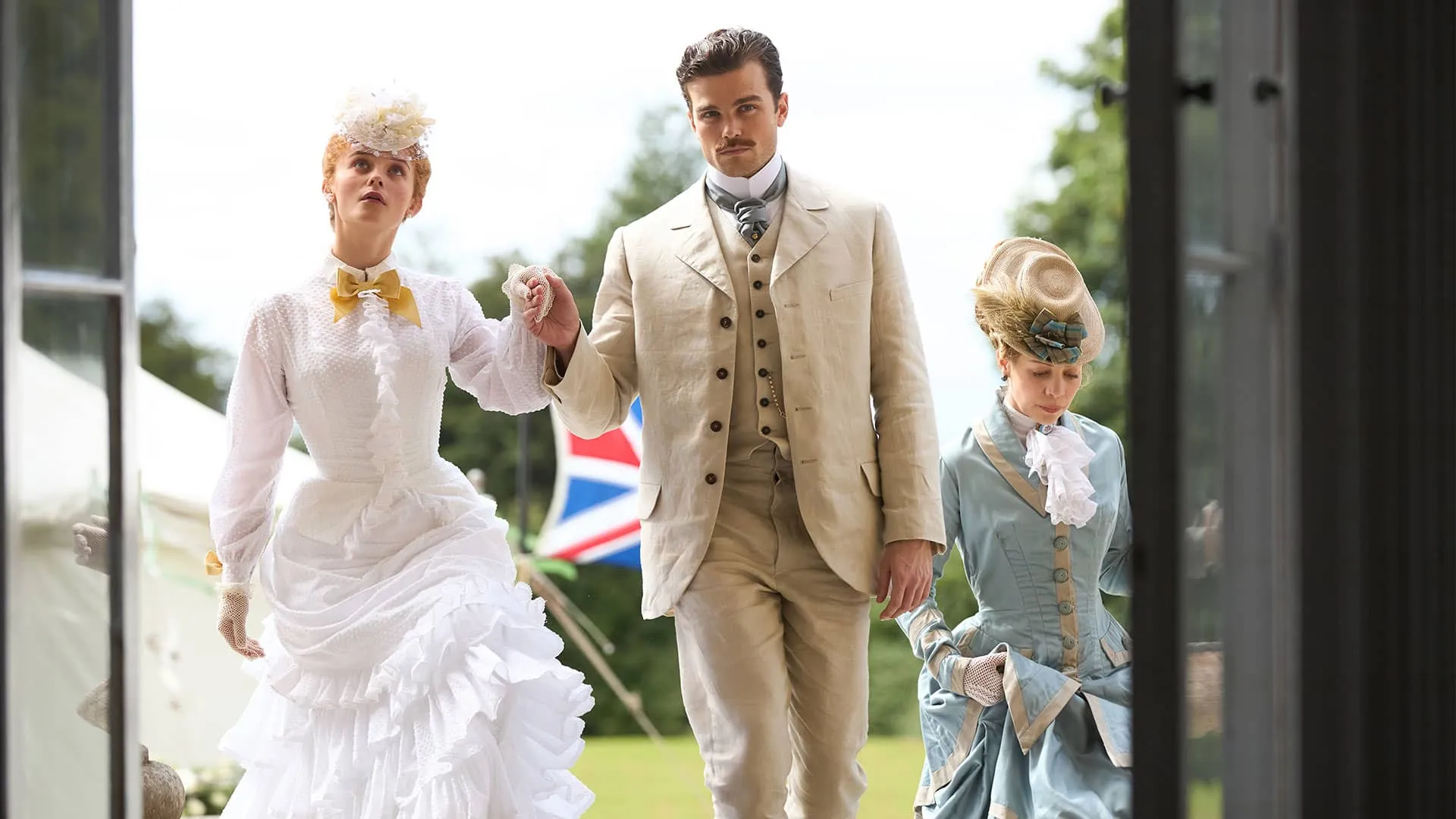 Holding hands, Irene and Soames enter a building. Irene, dressed in white, looks upwards at the interior, slightly awed, and Soames looks directly and proudly at the camera
