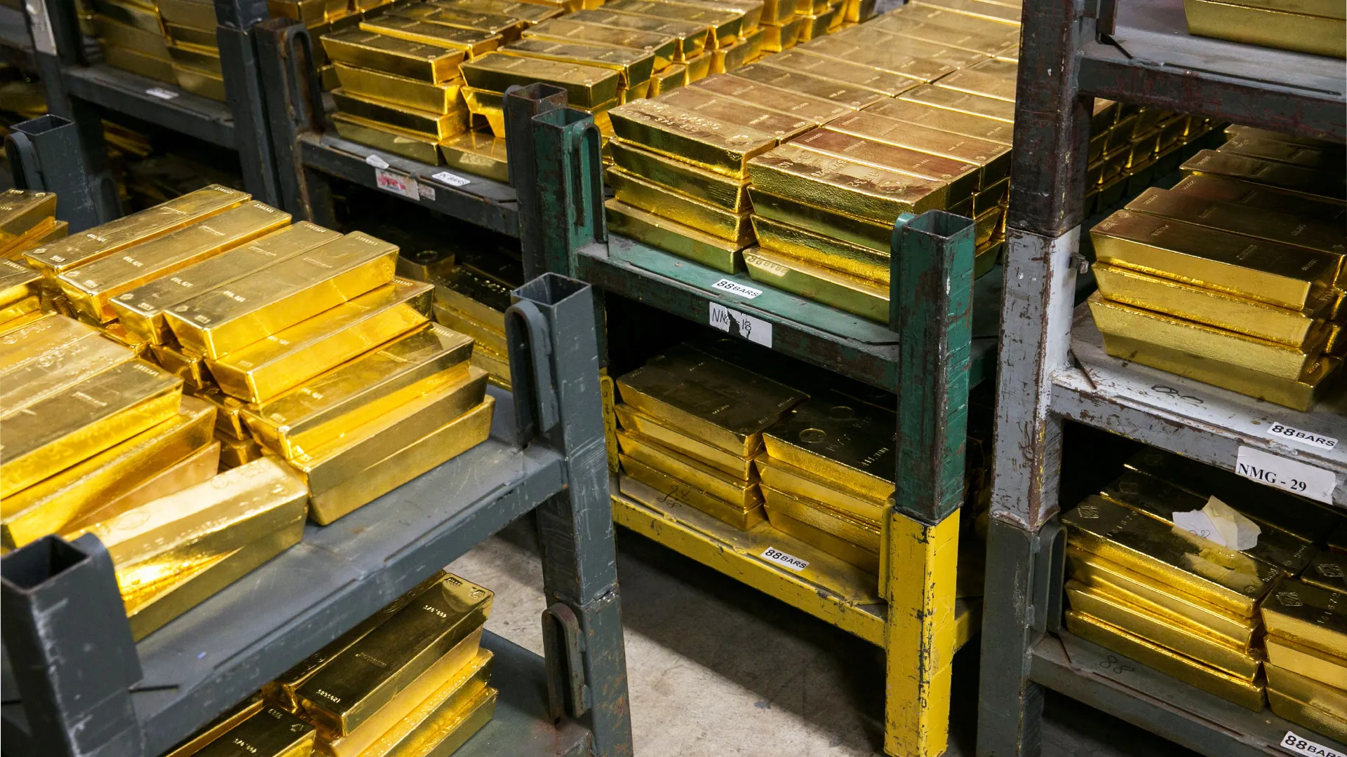 Stacks of pure gold bullion on shelves.