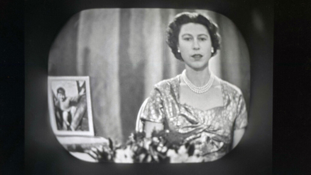 Black and white photo of Queen Elizabeth II giving her first Christmas message on BBC television in 1957.