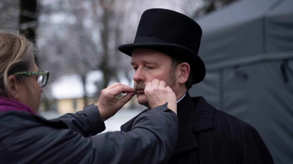 Simon Ludders getting his mustache touched up behind the scenes of Miss Scarlet and The Duke Season 4