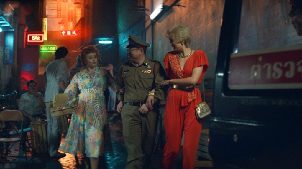 A scene from the PBS MASTERPIECE miniseries Nolly where Noele Gordon (Helena Bonham Carter) and a friend are led out of a Bangkok club.