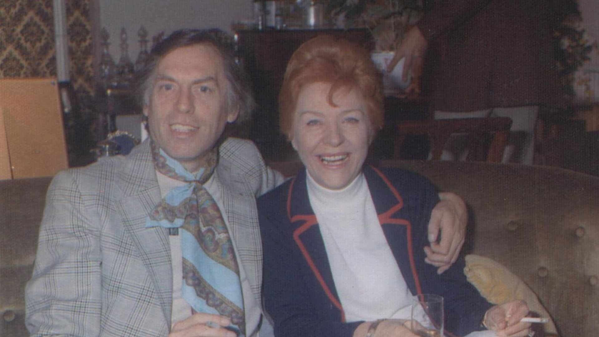 Larry Grayson and Noele Gordon sitting together on a couch, smiling