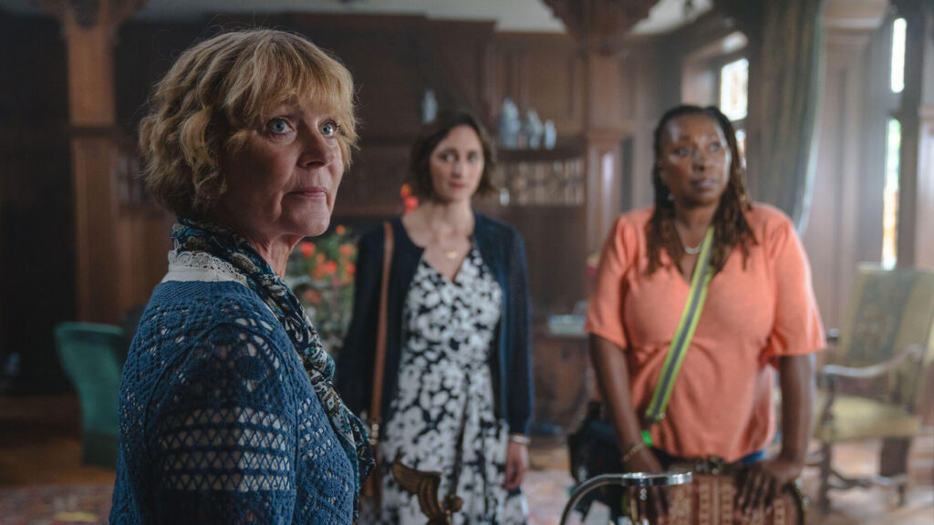 Scene from The Marlow Murder Club, airing on MASTERPIECE Mystery! and starring (left to right), Samantha Bond, Cara Horgan, and Jo Martin.