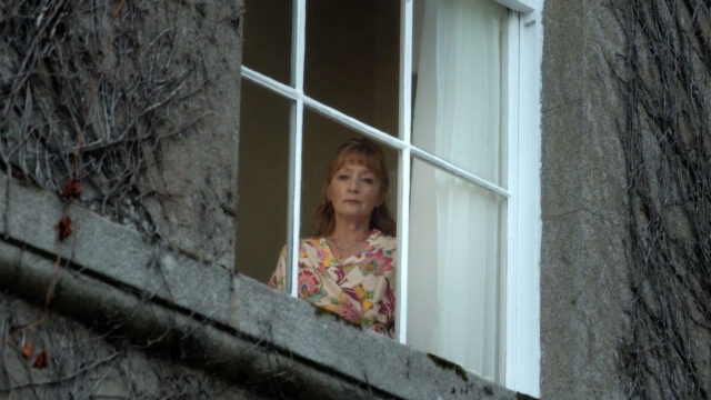 Lesley Manville as Susan Ryeland gazing out a window in Moonflower Murders