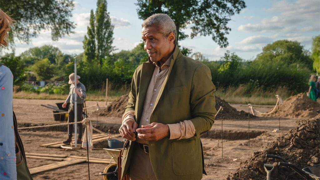 Hugh Quarshie as Professor Gifford, standing outdoors at an archaeological dig