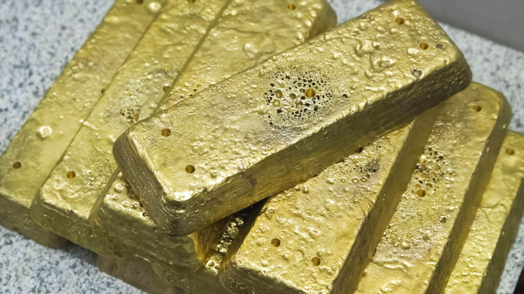 Color photo of stack of freshly smelted gold bars in raw material condition.