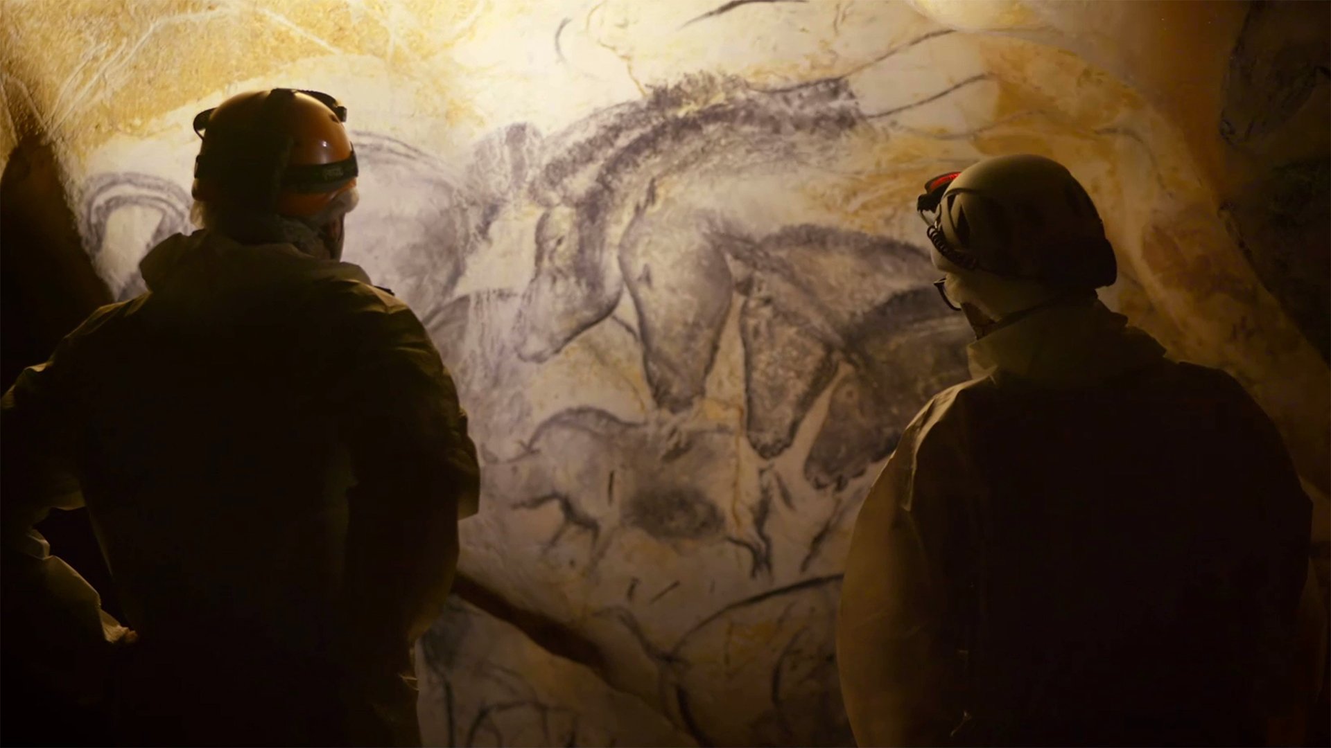 People looking at cave paintings