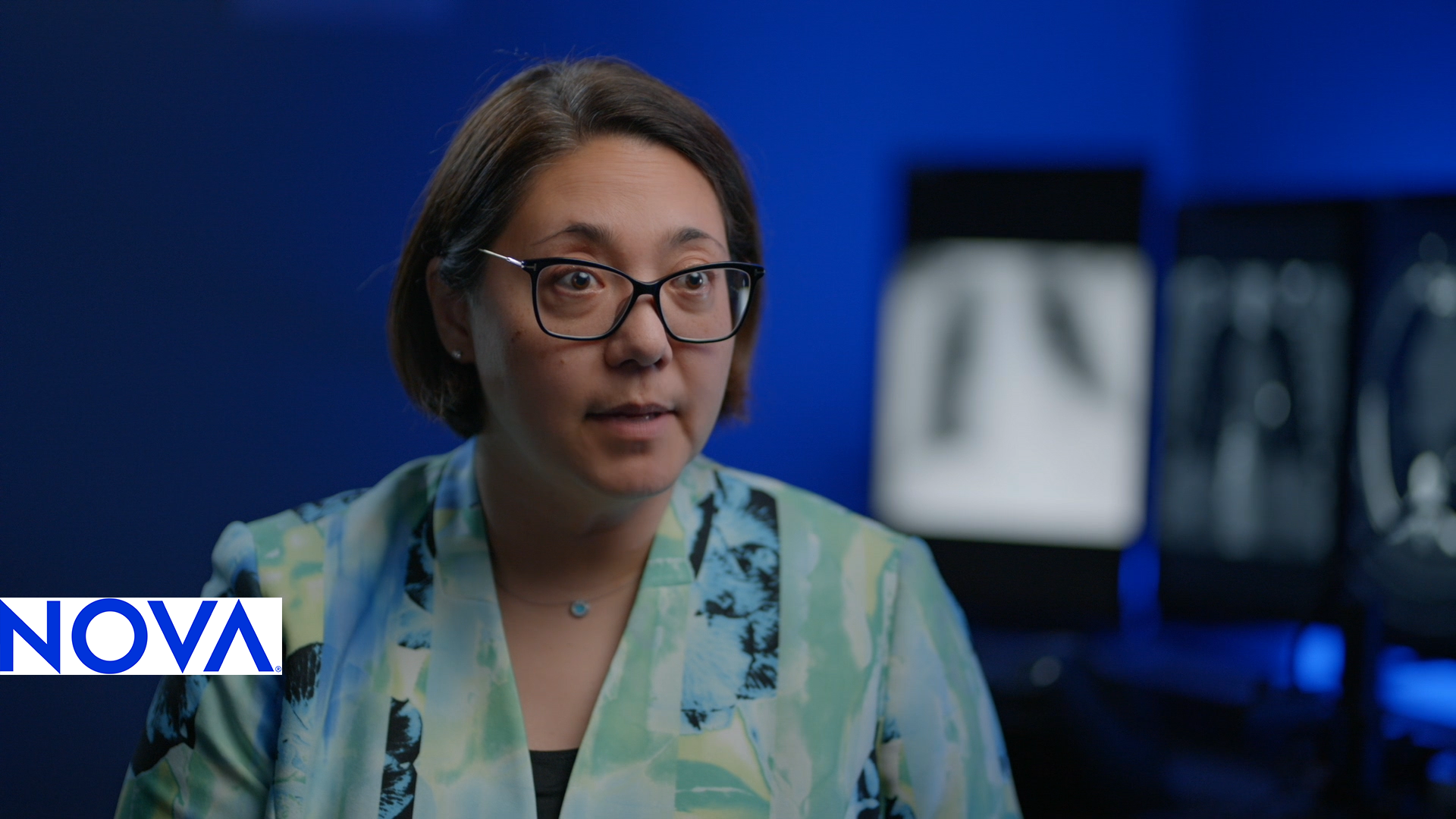 A woman sits in front of a computer