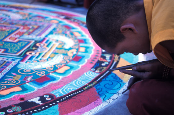Young man making sand mandala