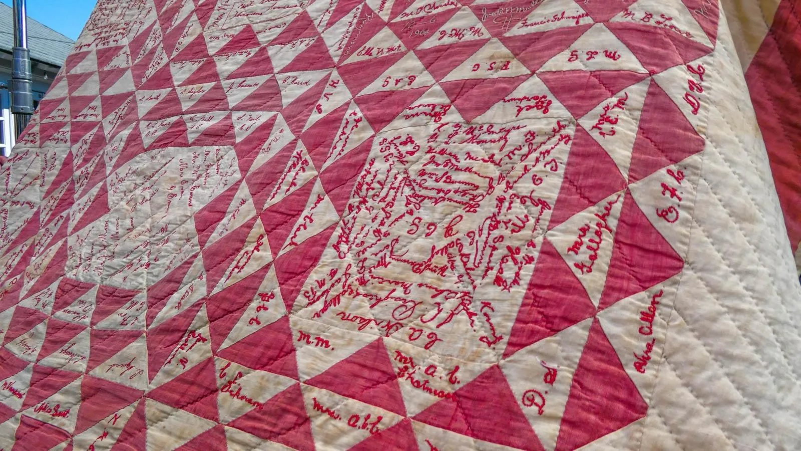 Close up on the details of a red and white colored quilt