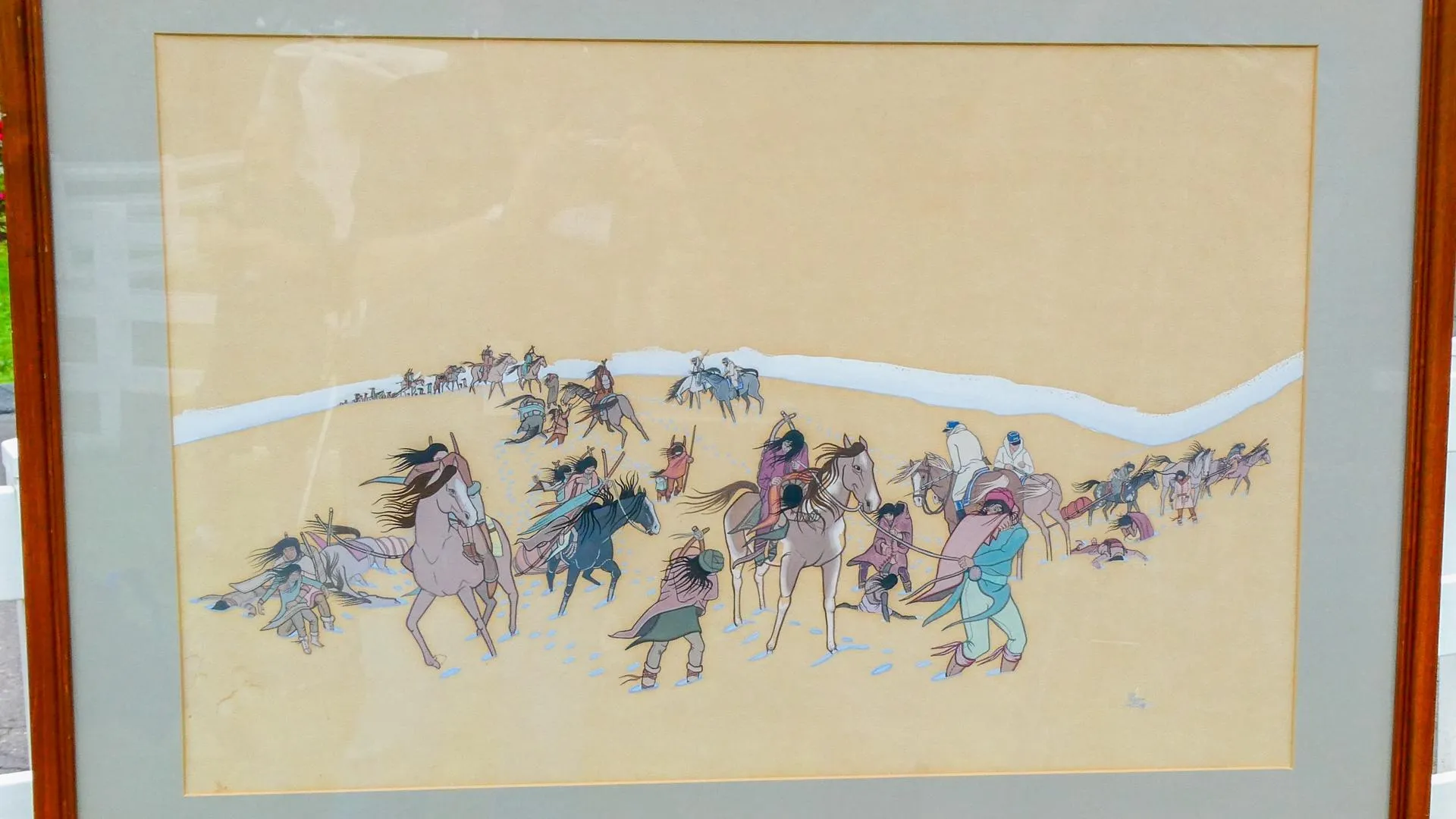 Close up on a painting of Native Americans in multi-color outfits on horseback traveling through the Trail of Tears.