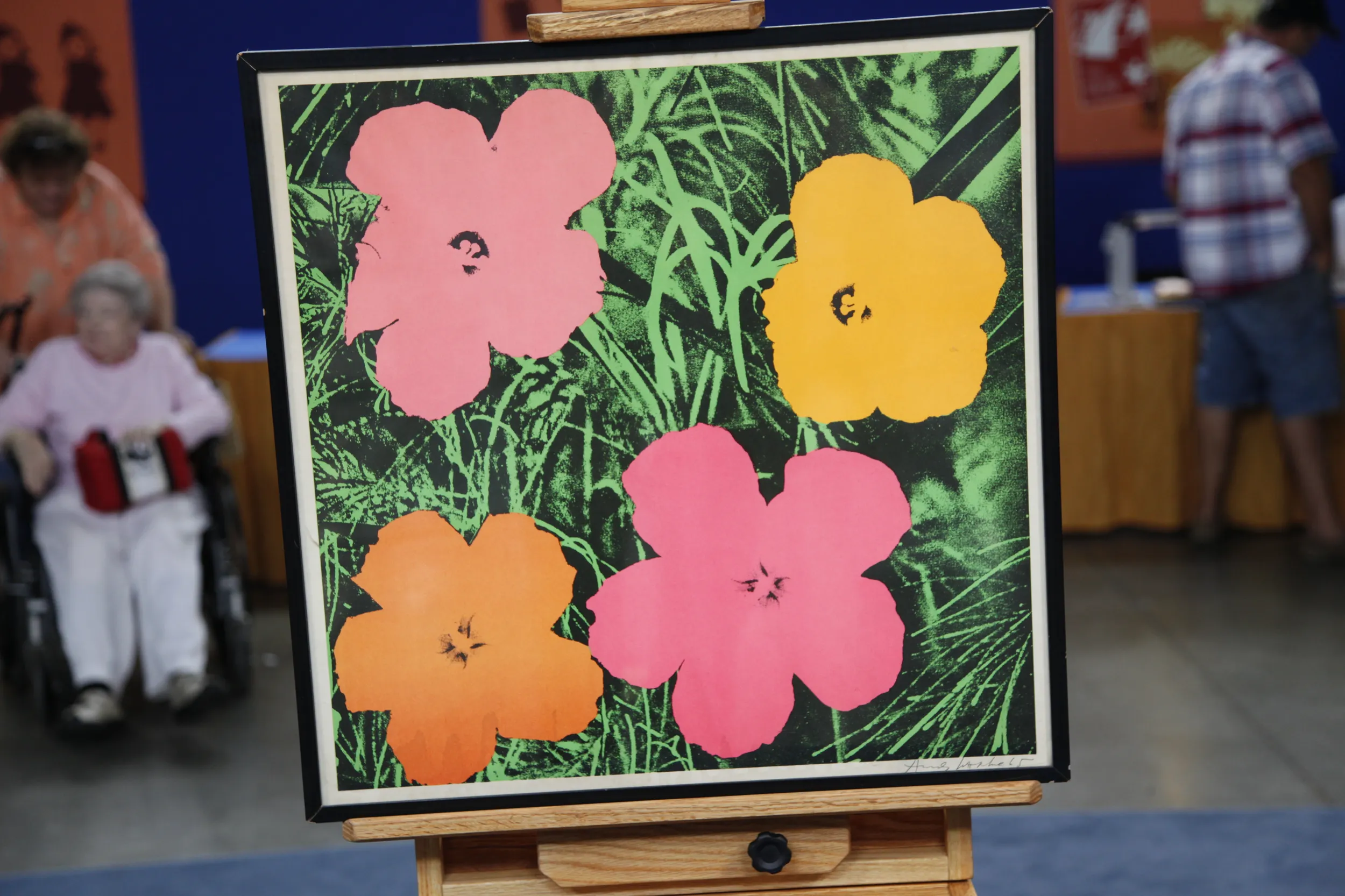 A framed lithograph featuring four monochromatic flower illustrations. Their backdrop is a green and black duo-tone design that depicts grass.
