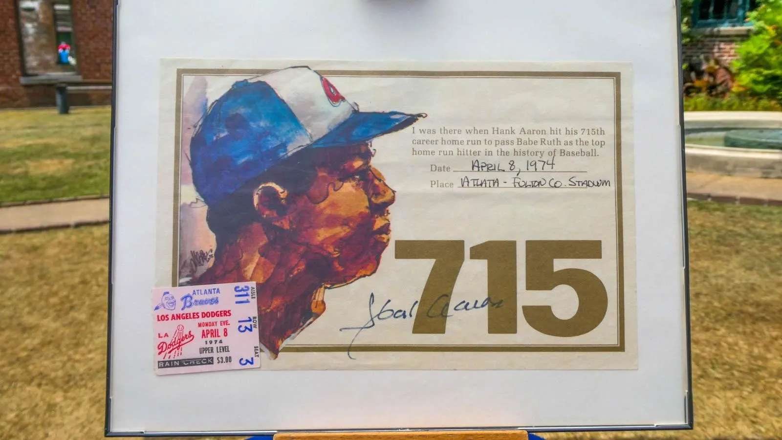 A signed certificate of Hank Aron's 715th home run with a watercolor portrait of Hank Aron place in a signed frame