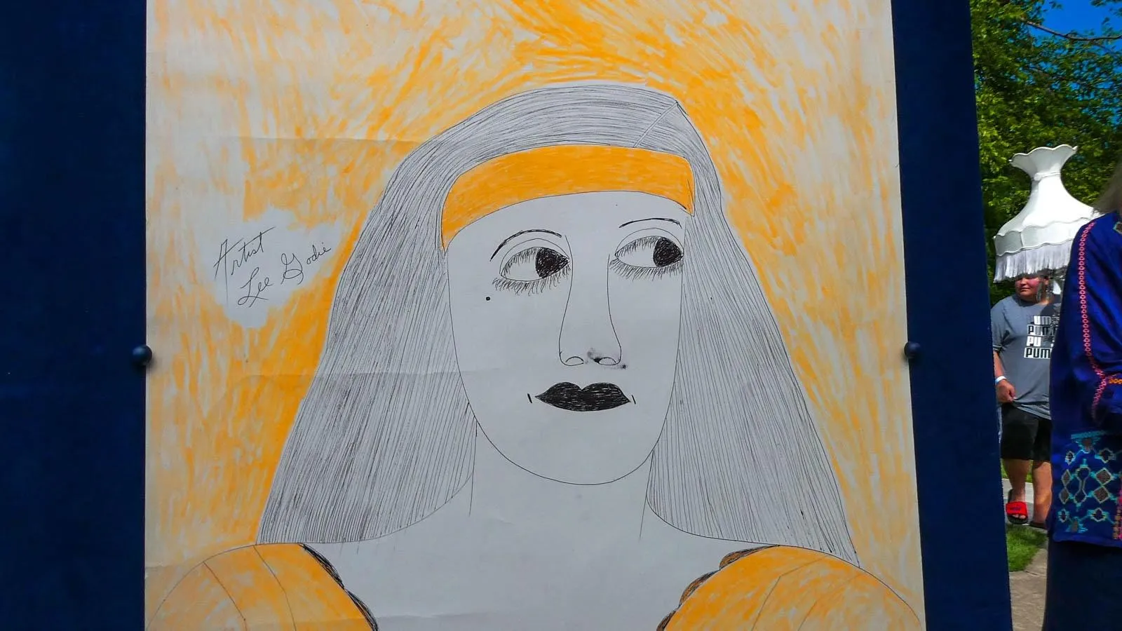 A Basic sketch of a women with lines for hair with a bright orange background mounted in a gold frame