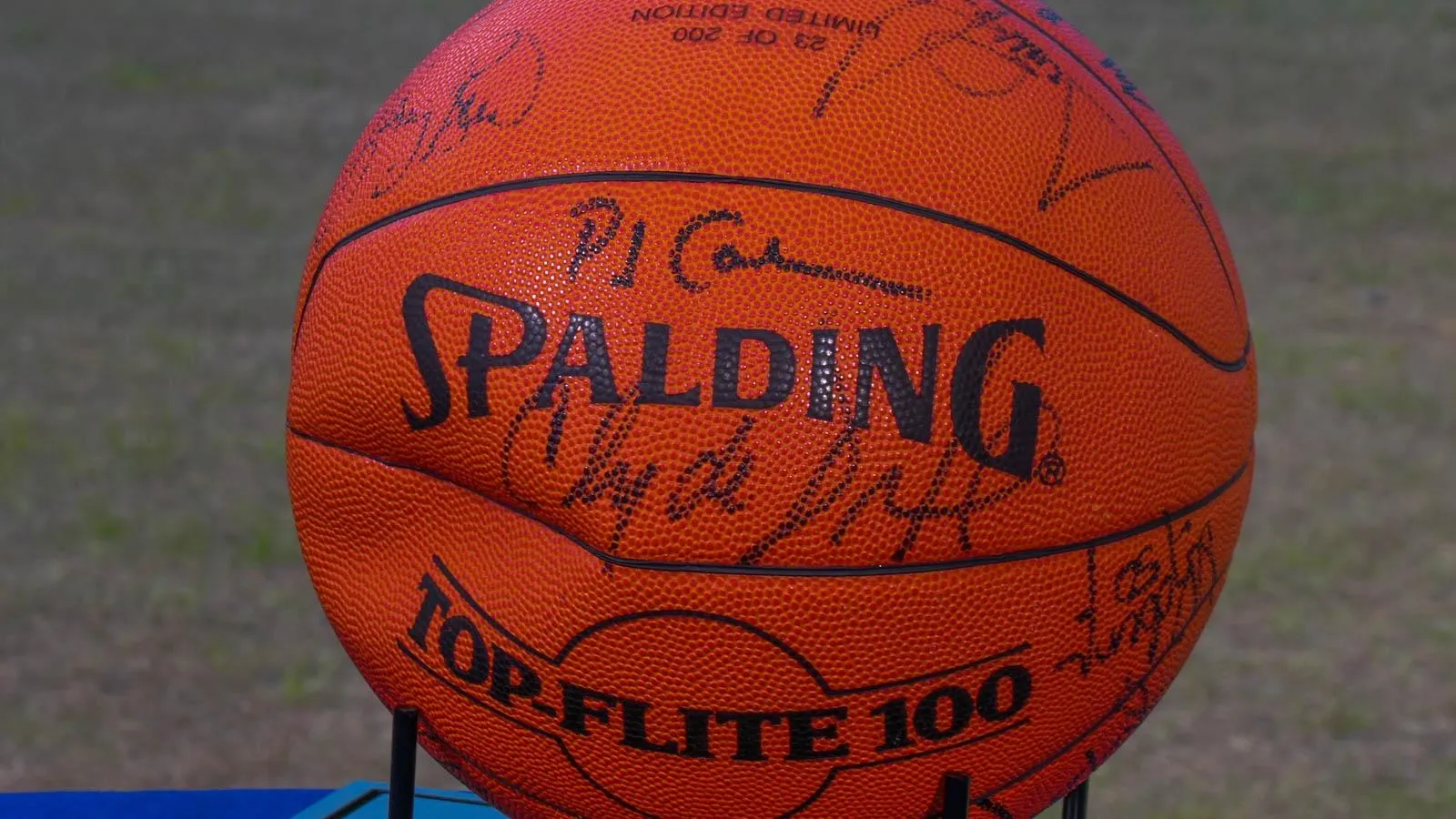 Close up of an orange spalding basketball with signatures in black sharpie.