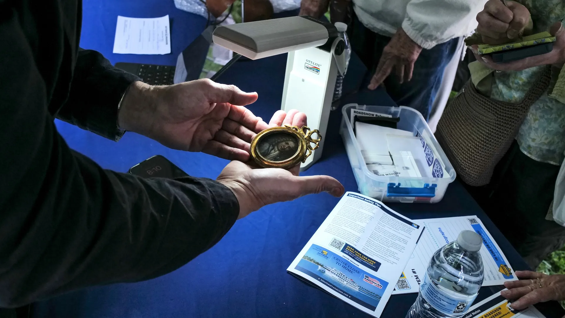 A photo of an appraiser holding a miniature portrait