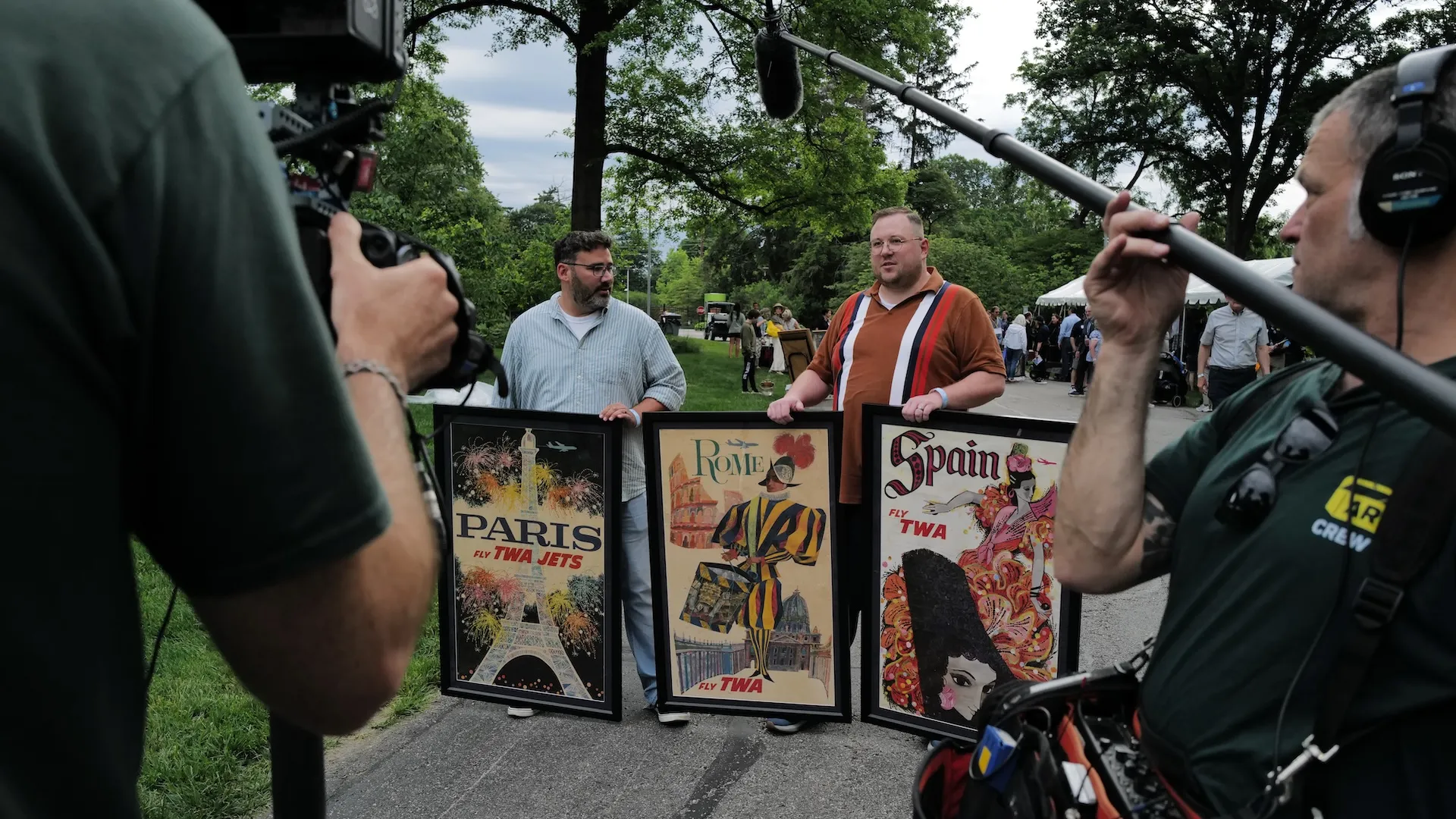 A behind the scenes photo of crew recording guests and their travel posters