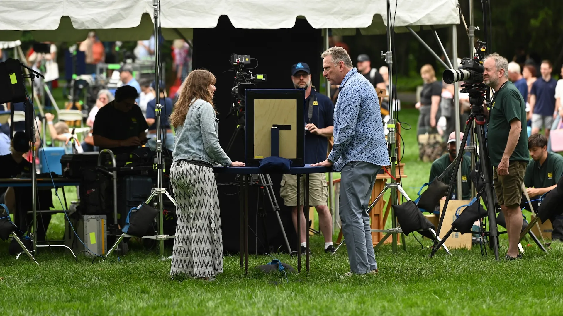 A behind the scenes photo of an appraisal with crew in the background