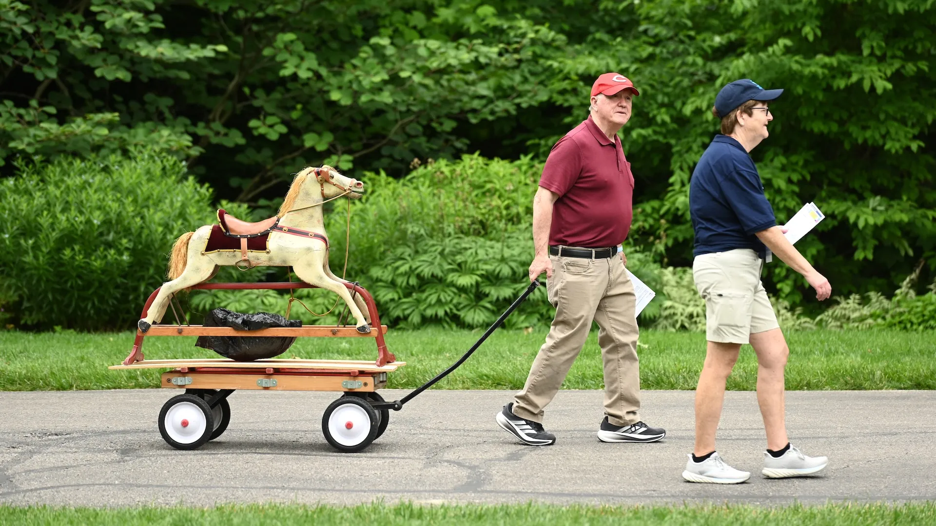 A photo of a guest pulling a rocking horse down the pathway