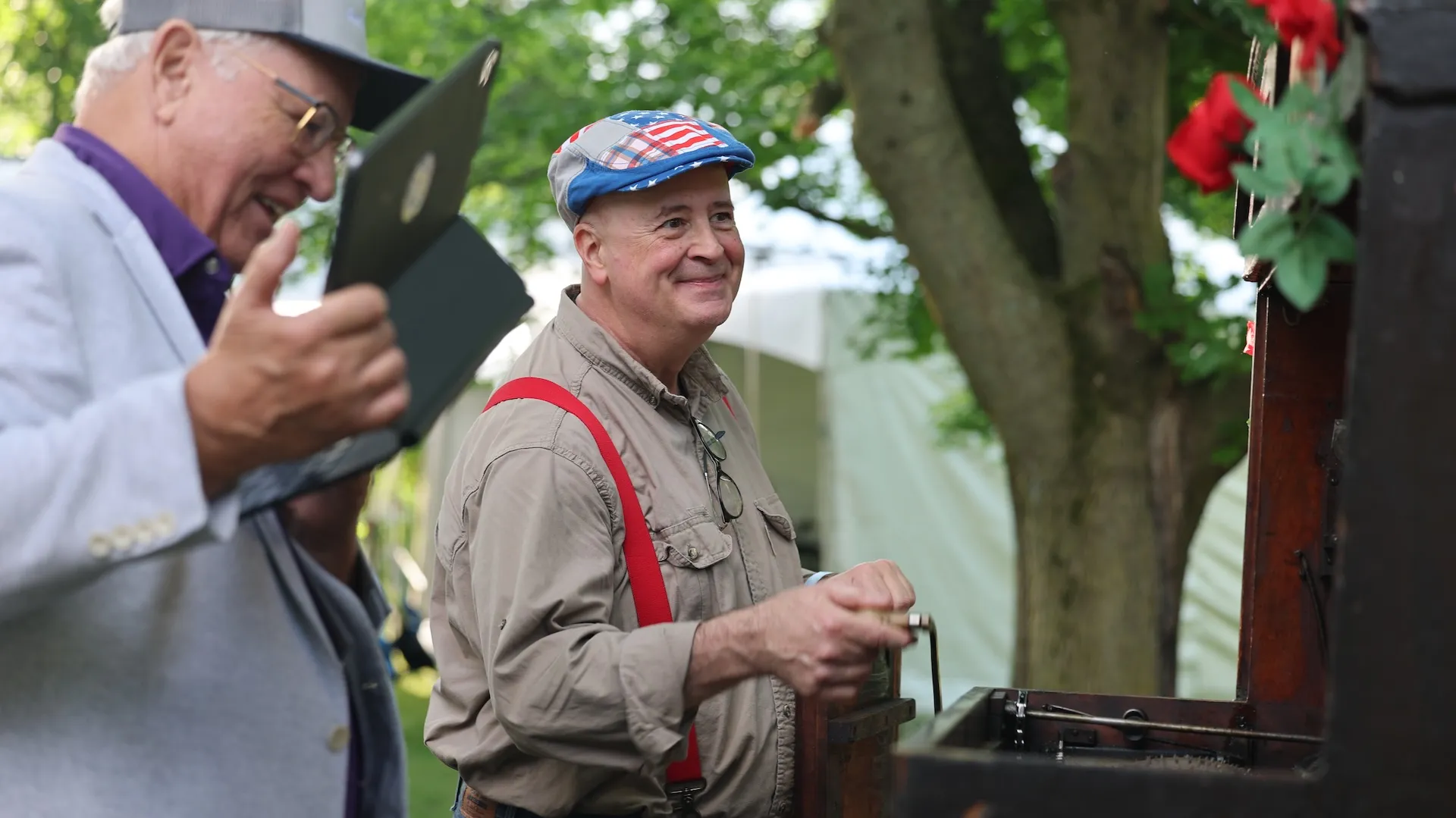 A photo of a guest and appraiser looking at a wooden object
