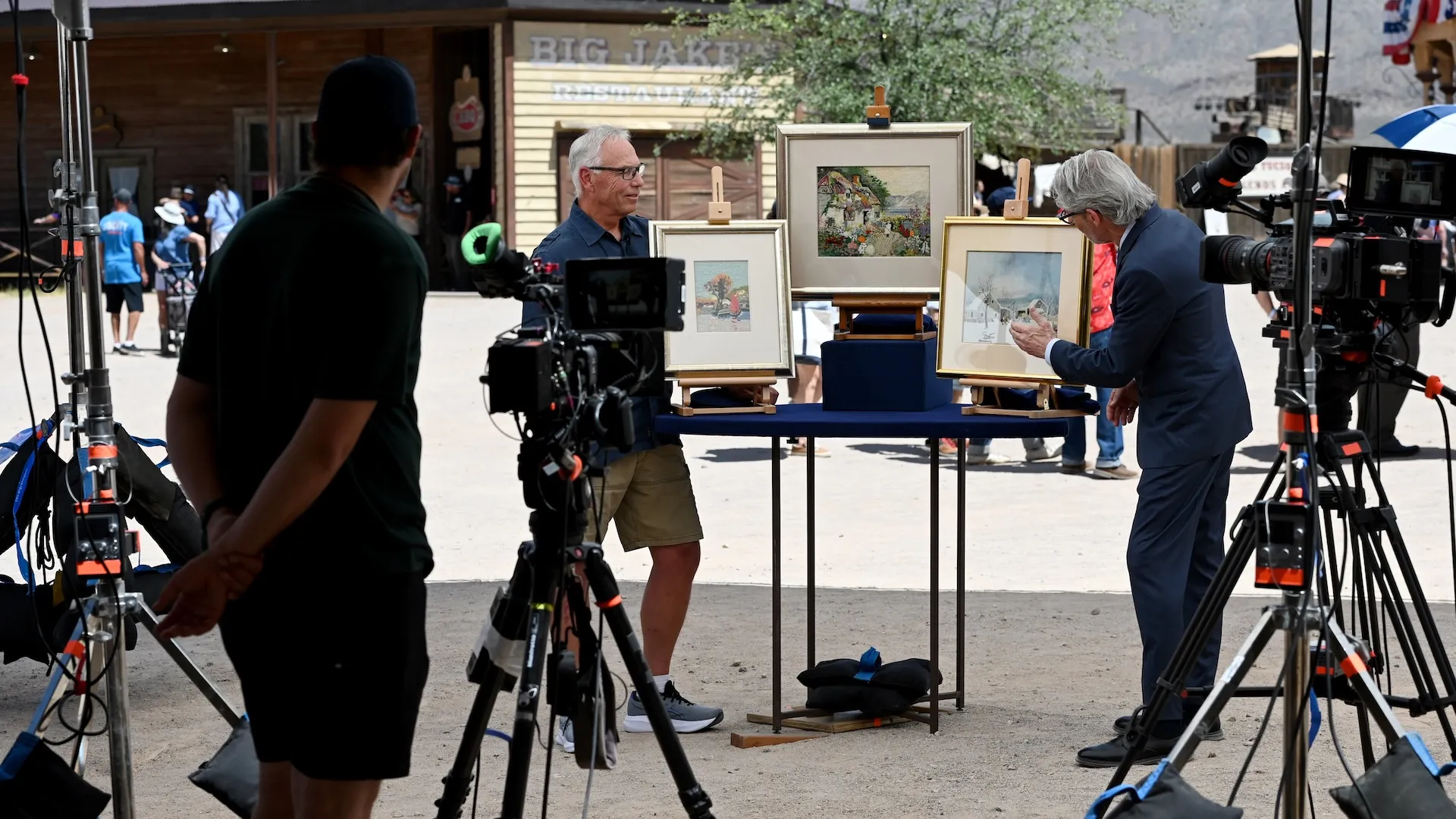 An appraisal of three paintings with camera crew in view