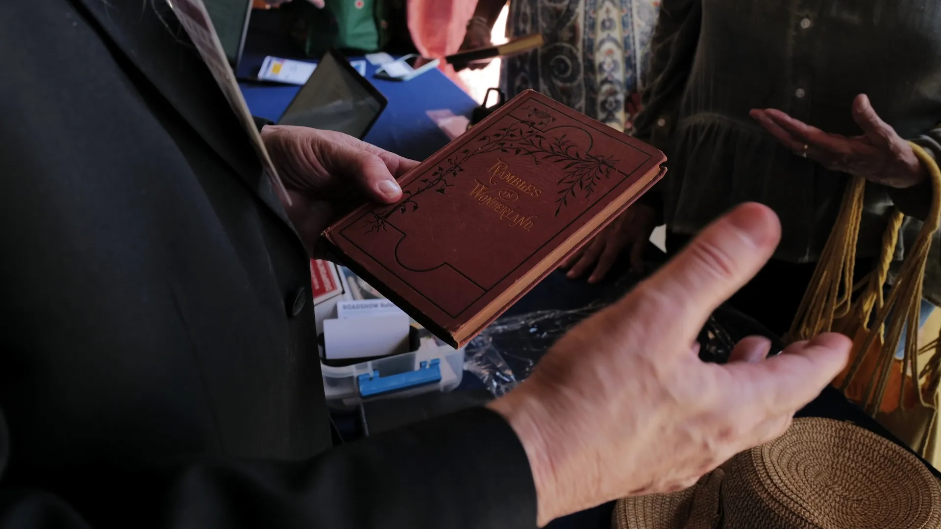 A photo of an appraiser examining a Rambles in Wonderland book