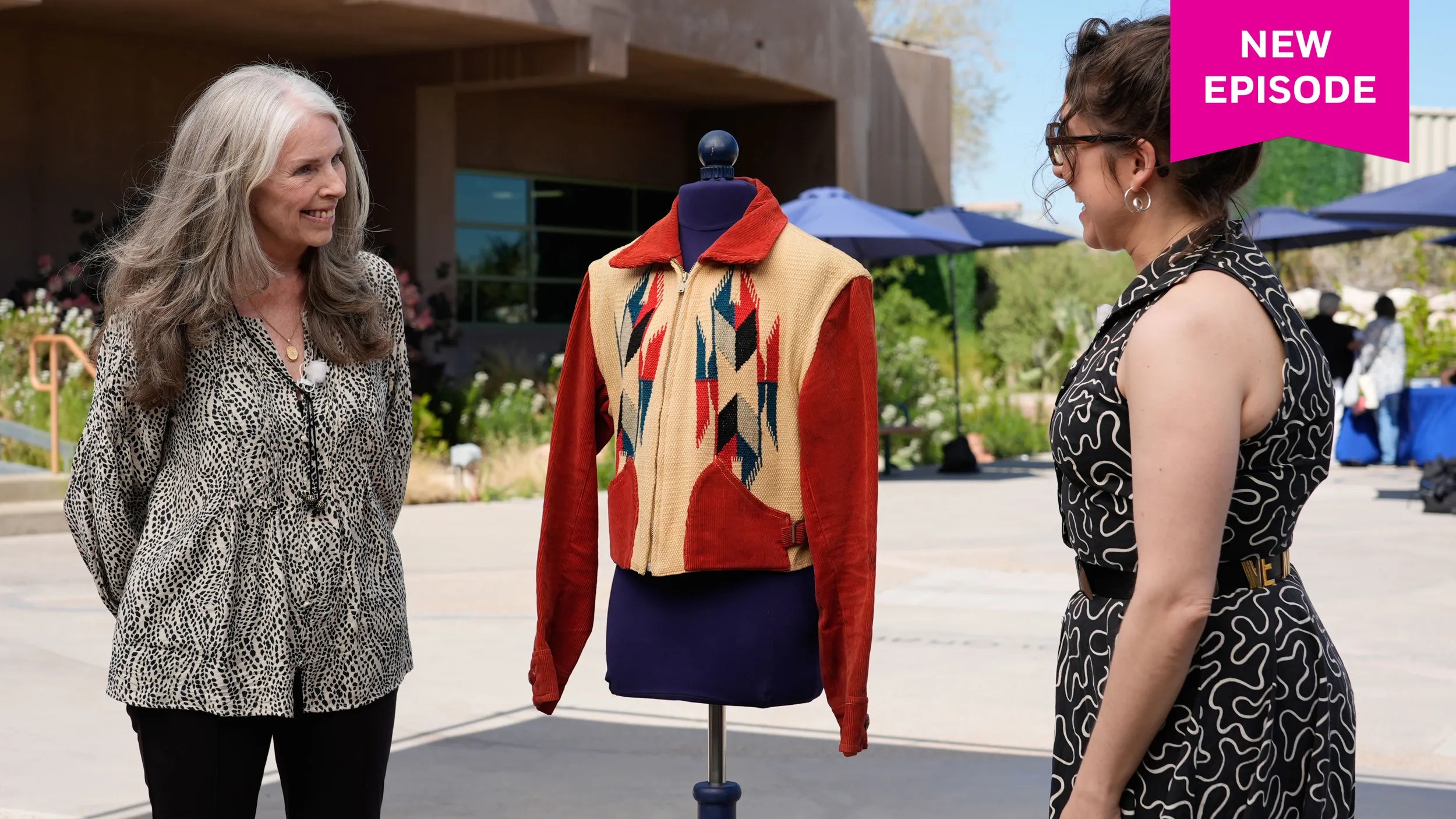 color photo of Textiles appraiser Martina D'Amato (right) talking with a guest (left) about her jacket.