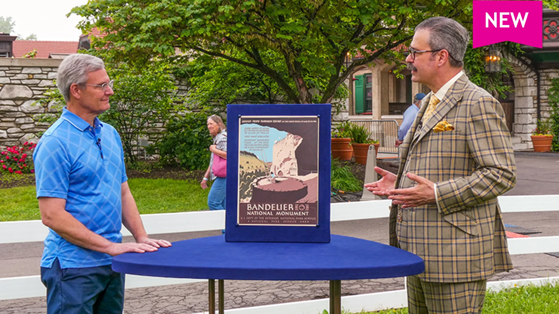 Color photo of a man listening to posters expert Nicholas Lowry discussing a Bandelier National Monument poster