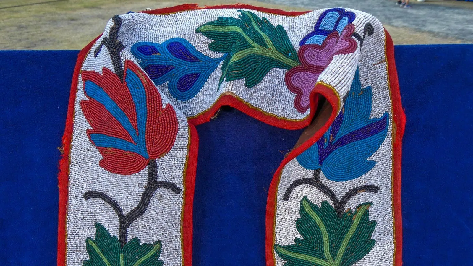 close up of a beaded stole of flowers against a white background
