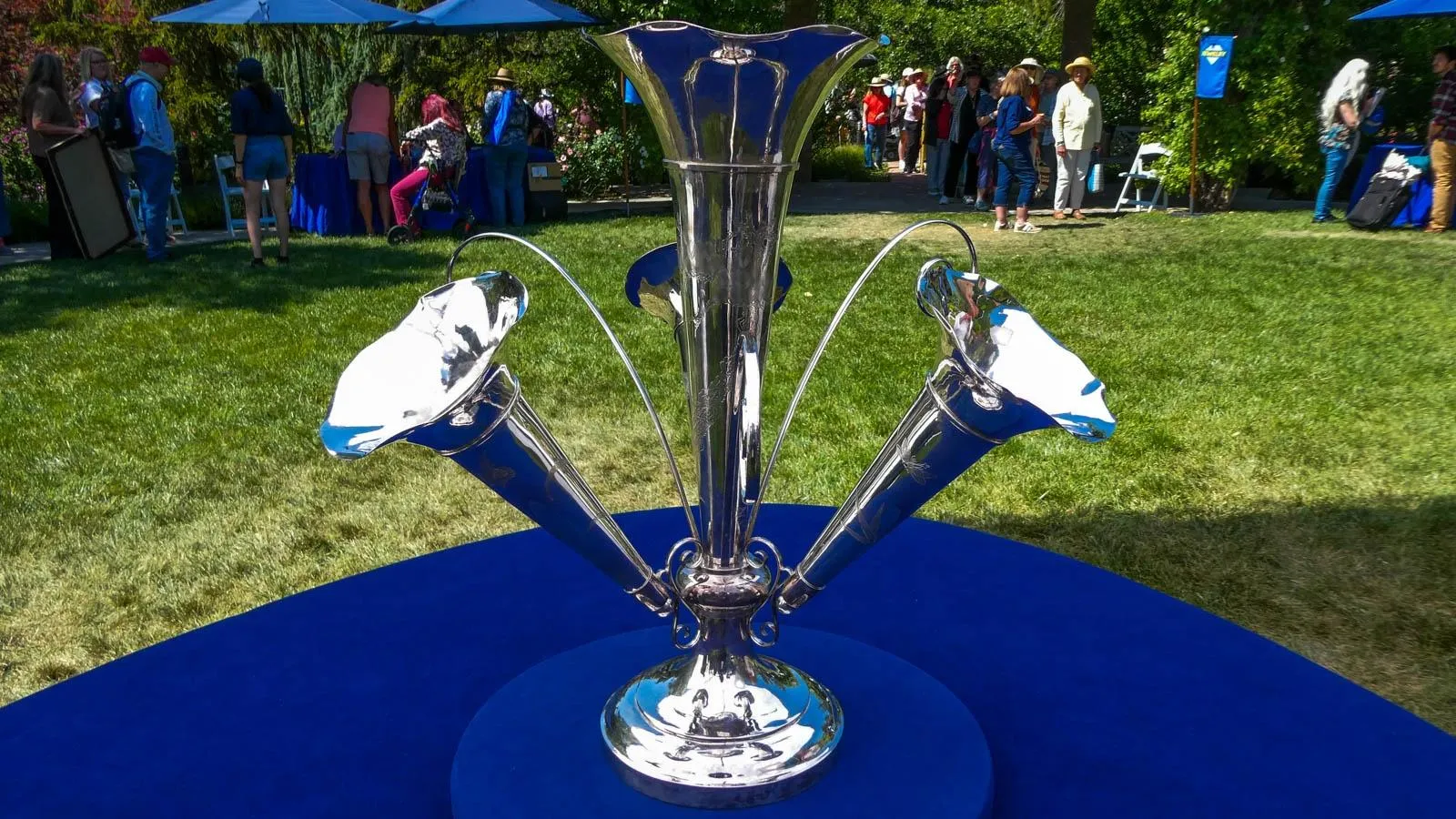 Silver piece with four trumpet-like shapes - one that sprouts, upward, backwards, left, and right.