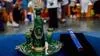 Emerald green set of pitcher, plate, and four cups with gold accents placed on table in expo hall.