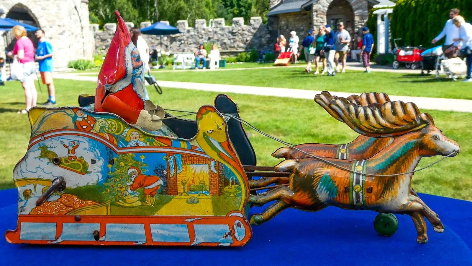 A close up of a wind up toy of Santa and his reindeer in a sketch like art style.