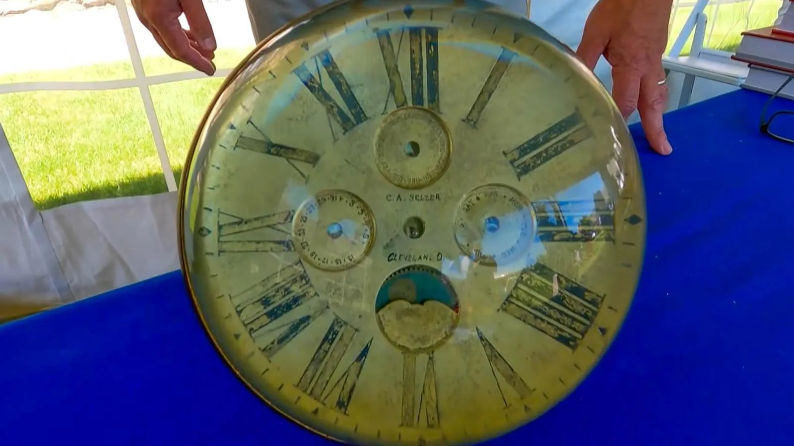 An Orb like clock sits on top of a royal blue table.