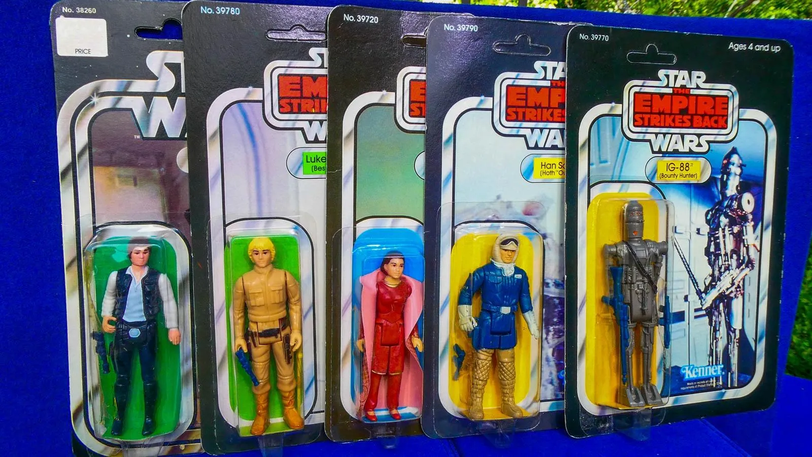 Five multicolored action figures in their packaging of various star wars characters such as Luke Skywalker, Han Solo, and Princess Leia.